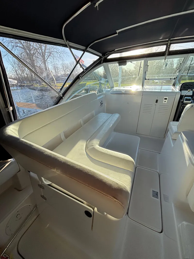 Slide: The Image of 2007 Tiara Yachts 2900 Coronet interior with white seating and helm, sunlit view. - 14
