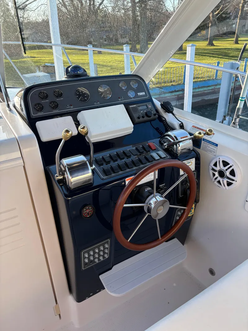 Slide: The Image of 2007 Tiara Yachts 2900 Coronet helm with controls and steering wheel, docked outdoors. - 16