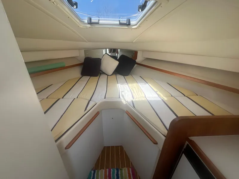 Slide: The Image of 2007 Tiara Yachts 2900 Coronet cabin interior with striped bedding and cushions. - 27