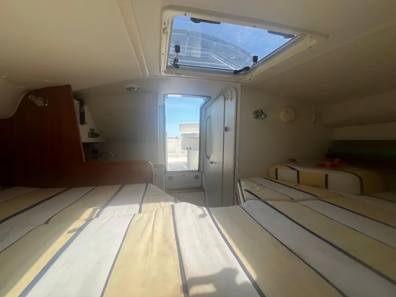 Slide: The Image of Interior cabin of 2007 Tiara Yachts 2900 Coronet with striped bedding and skylight. - 30