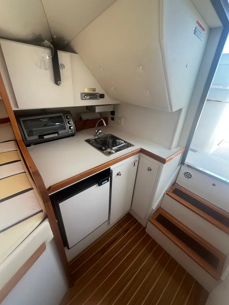 Slide: The Image of 2007 Tiara Yachts 2900 Coronet interior with kitchenette, sink, and compact appliances. - 33