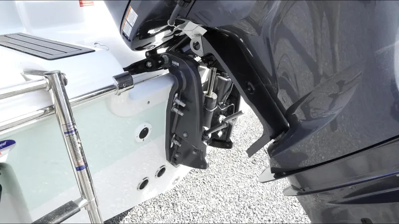 Slide: The Image of 2025 Tidewater 220 LXF boat engine and ladder detail on gravel surface. - 11