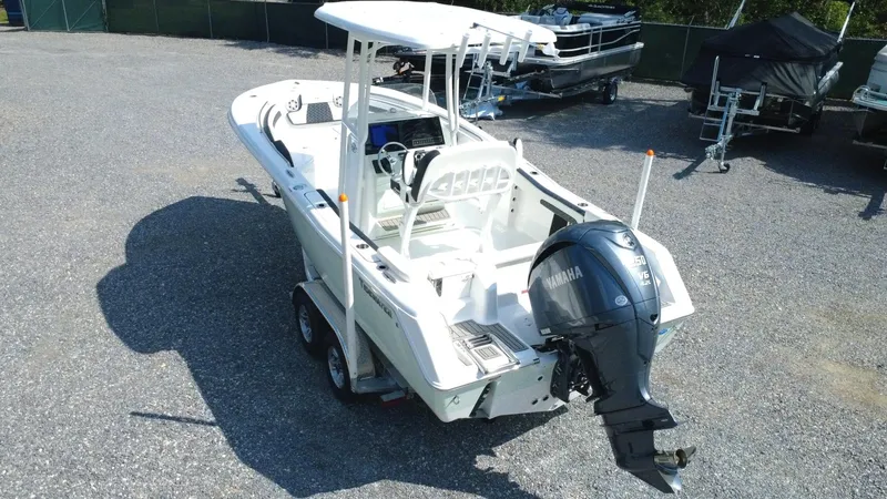 Slide: The Image of 2025 Tidewater 220 LXF boat with Yamaha outboard engine, parked on gravel. - 2