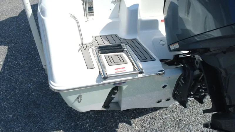 Slide: The Image of 2025 Tidewater 220 LXF boat stern with ladder and motor, on a sunny day. - 29