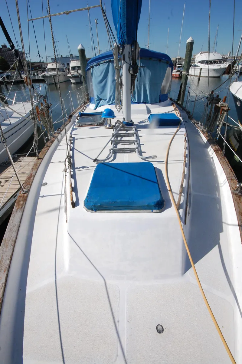 Slide: The Image of 1981 Endeavour 40 sailboat deck with blue accents, docked in a marina. - 11