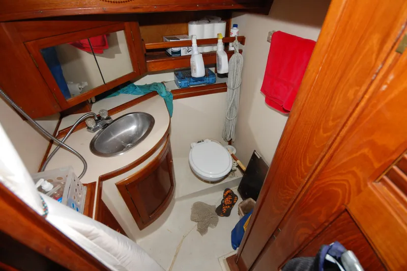 Slide: The Image of Compact bathroom in 1981 Endeavour 40 yacht with sink, toilet, and wooden cabinetry. - 24