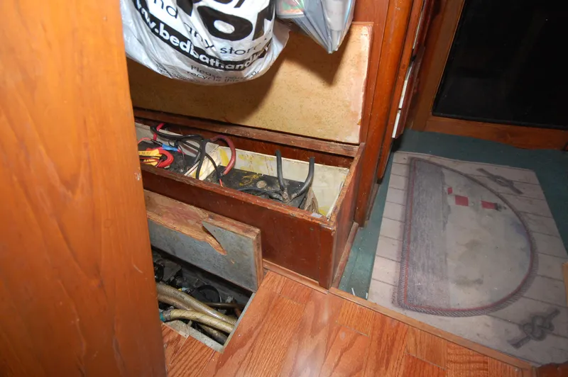 Slide: The Image of Interior view of 1981 Endeavour 40 sailboat showing open storage compartments with wiring. - 29