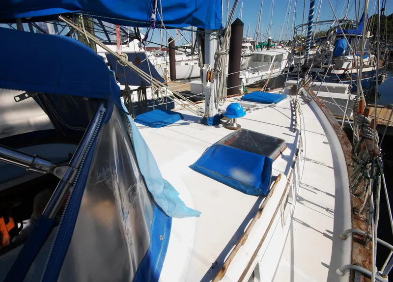 Slide: The Image of 1981 Endeavour 40 sailboat deck with blue covers and rigging in marina. - 7