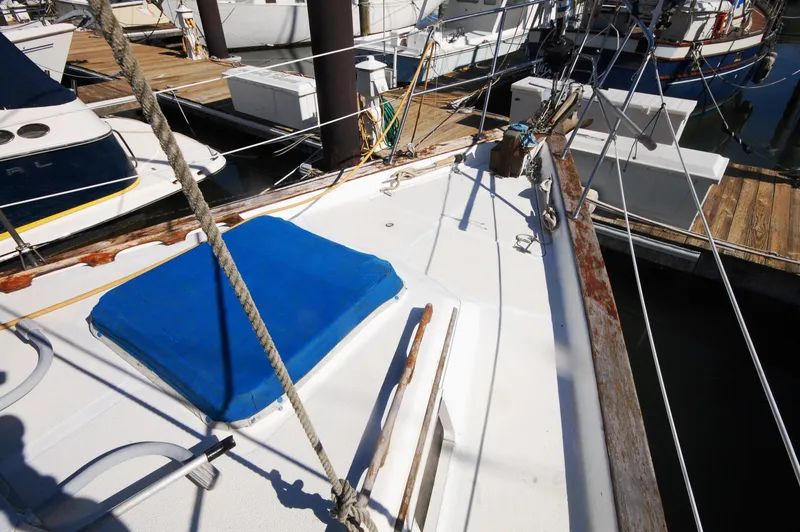 Slide: The Image of 1981 Endeavour 40 sailboat deck with blue hatch cover, docked at marina. - 8