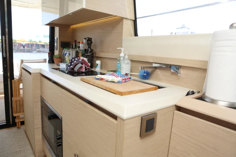 Slide: The Image of Modern kitchen interior on 2017 Beneteau Monte Carlo 4 yacht, featuring sleek countertops and appliances. - 16