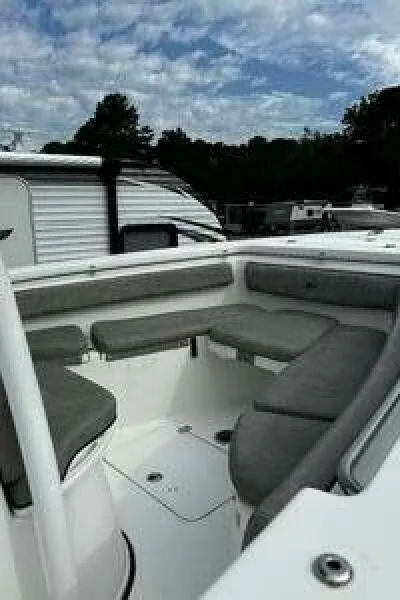 Slide: The Image of 2022 Sea Pro 219 Center Console boat with cushioned seating, parked outdoors. - 11