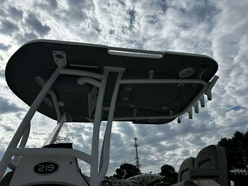 Slide: The Image of 2022 Sea Pro 219 Center Console boat under cloudy sky, showcasing T-top and seating. - 5
