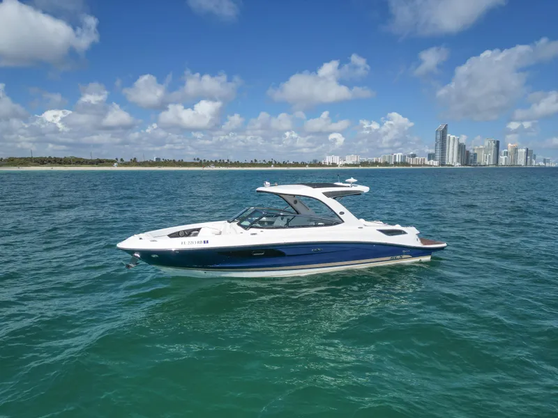Slide: The Image of 2015 Sea Ray 350 SLX boat cruising on clear blue water near a city skyline. - 11