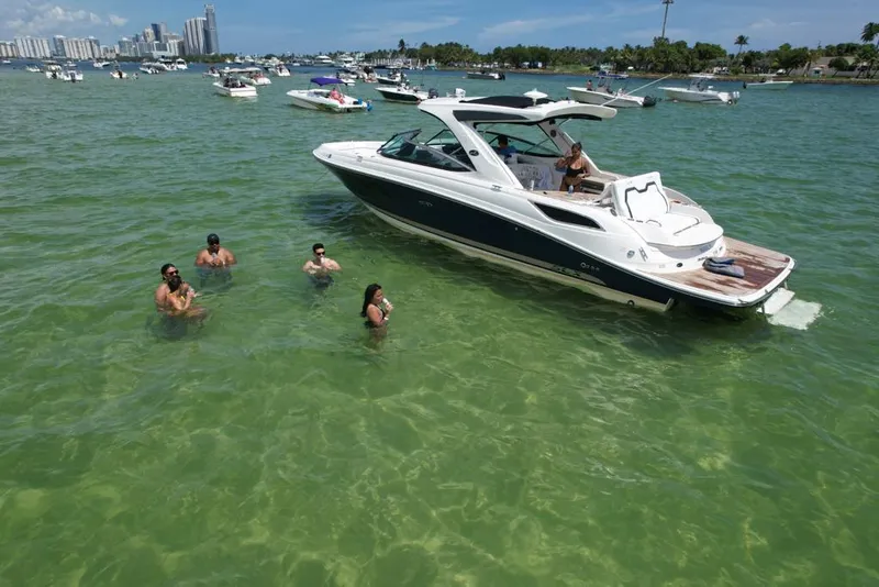 Slide: The Image of 2015 Sea Ray 350 SLX boat with people swimming nearby in clear green water. - 13