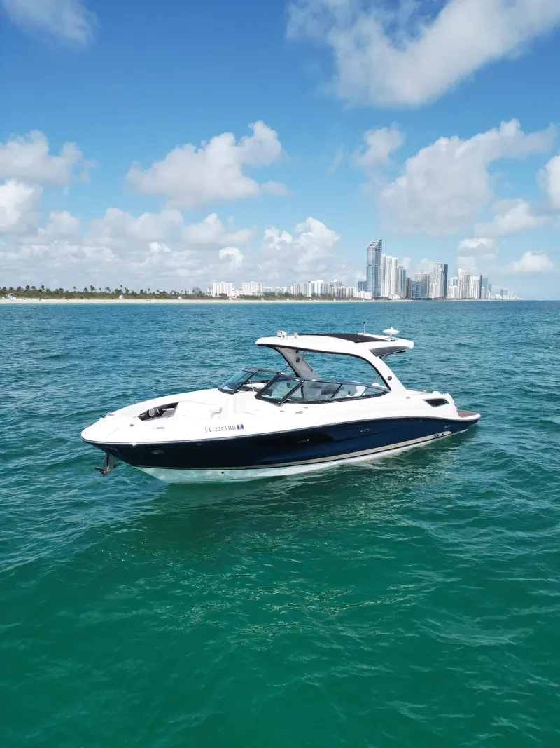 Slide: The Image of 2015 Sea Ray 350 SLX boat on turquoise water with city skyline in background. - 15