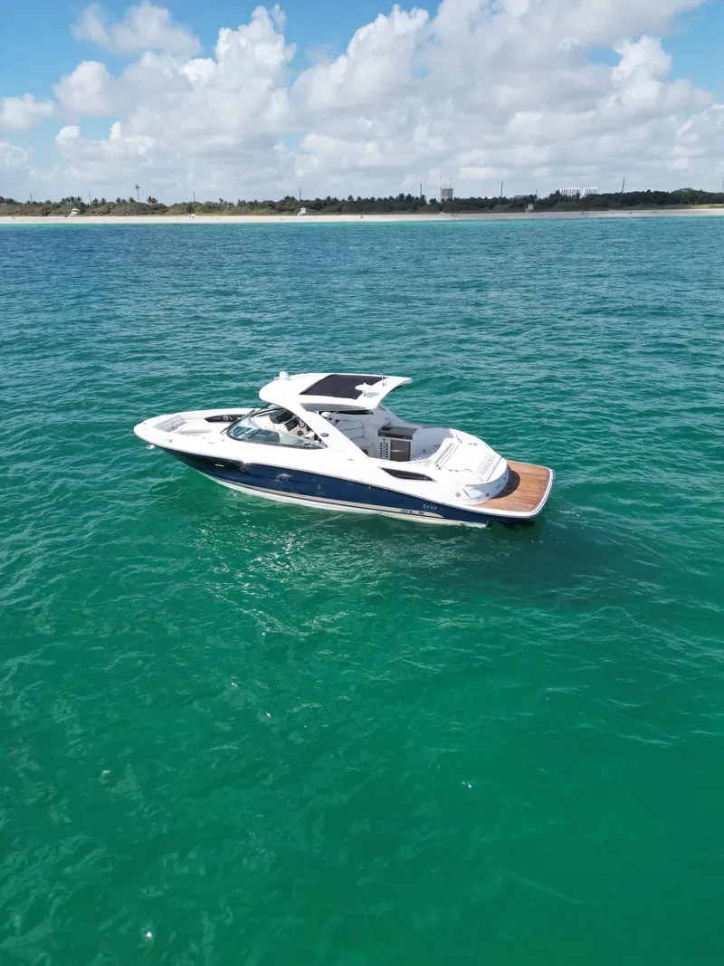 Slide: The Image of 2015 Sea Ray 350 SLX boat on clear turquoise water under a partly cloudy sky. - 17