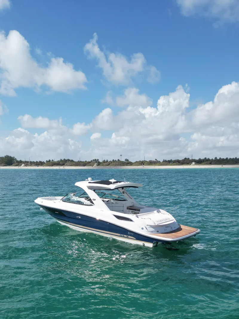Slide: The Image of 2015 Sea Ray 350 SLX boat cruising on clear blue water under a sunny sky. - 18