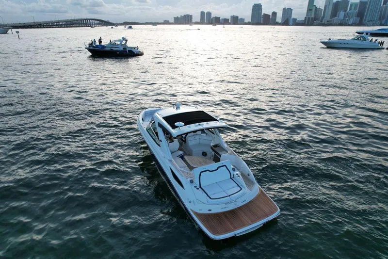 Slide: The Image of 2015 Sea Ray 350 SLX boat on water with city skyline in background. - 2