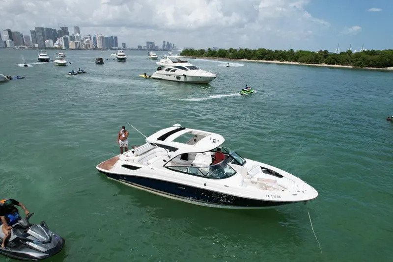 Slide: The Image of 2015 Sea Ray 350 SLX boat cruising in a busy waterway with city skyline. - 20