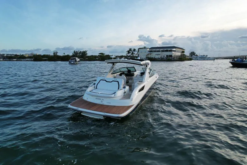 Slide: The Image of 2015 Sea Ray 350 SLX boat cruising on a calm lake at sunset. - 23