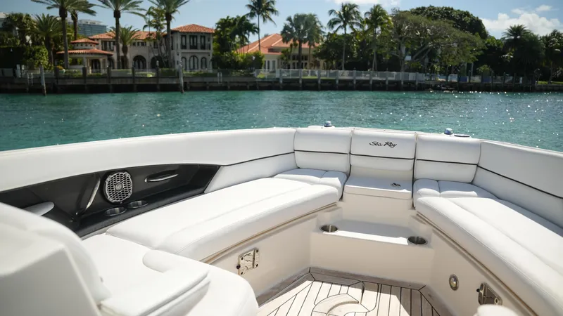Slide: The Image of 2015 Sea Ray 350 SLX boat interior with luxurious seating, docked near waterfront homes. - 26