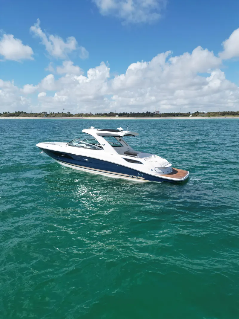 Slide: The Image of 2015 Sea Ray 350 SLX boat on clear blue water under a partly cloudy sky. - 3