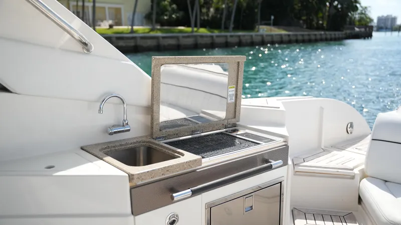 Slide: The Image of Luxury outdoor kitchen on 2015 Sea Ray 350 SLX boat, featuring sink and grill by the water. - 35