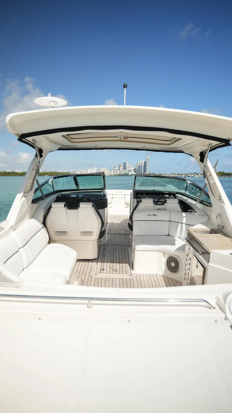 Slide: The Image of 2015 Sea Ray 350 SLX boat interior with seating, open water, and city skyline in background. - 41