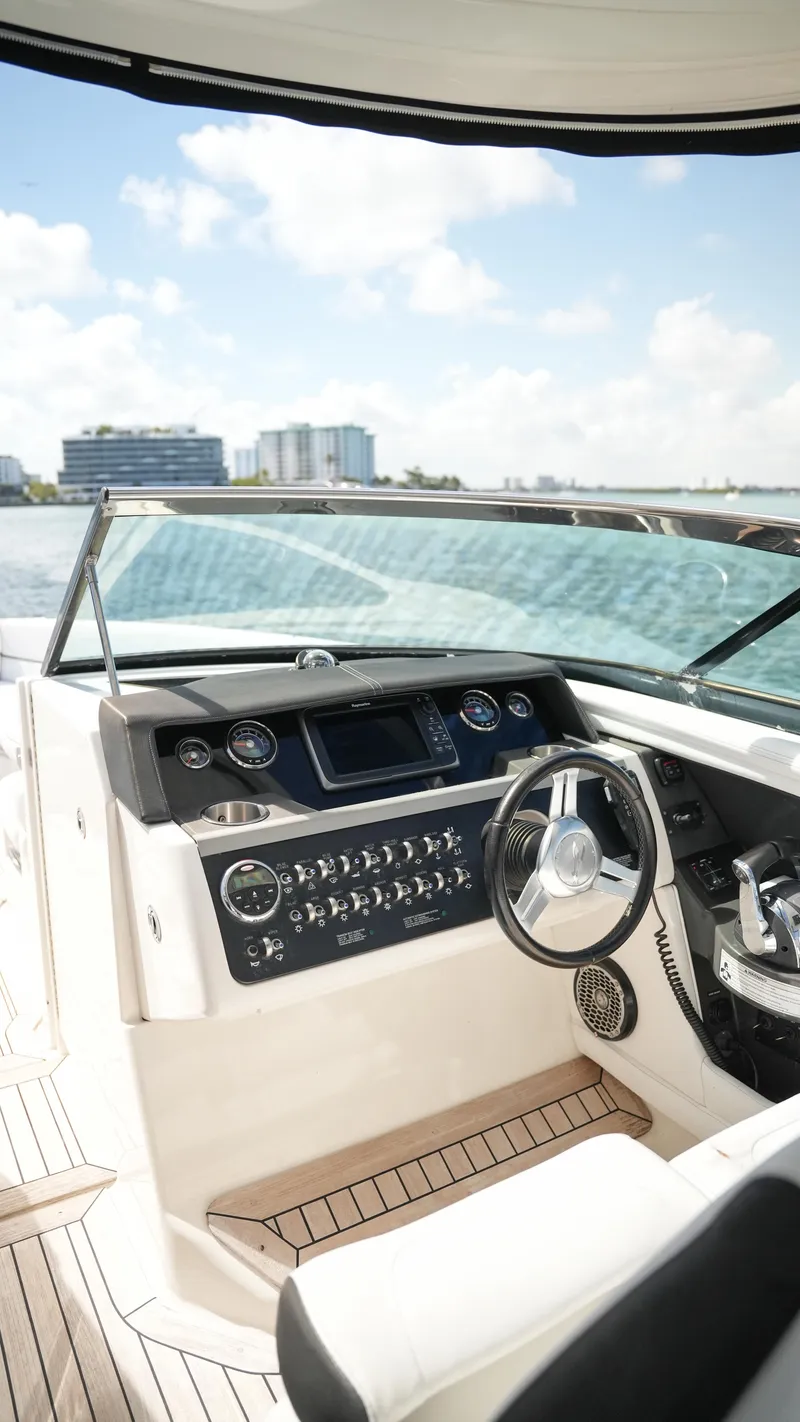 Slide: The Image of 2015 Sea Ray 350 SLX boat cockpit with modern controls and waterfront view. - 43