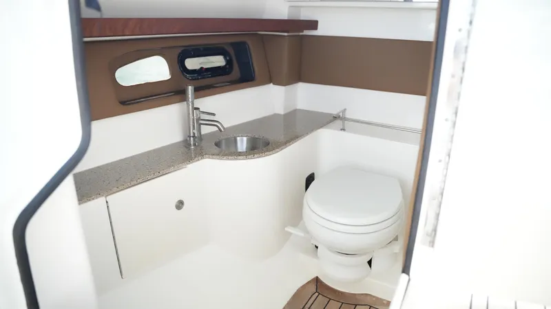 Slide: The Image of 2015 Sea Ray 350 SLX boat bathroom with sink, toilet, and window. - 47