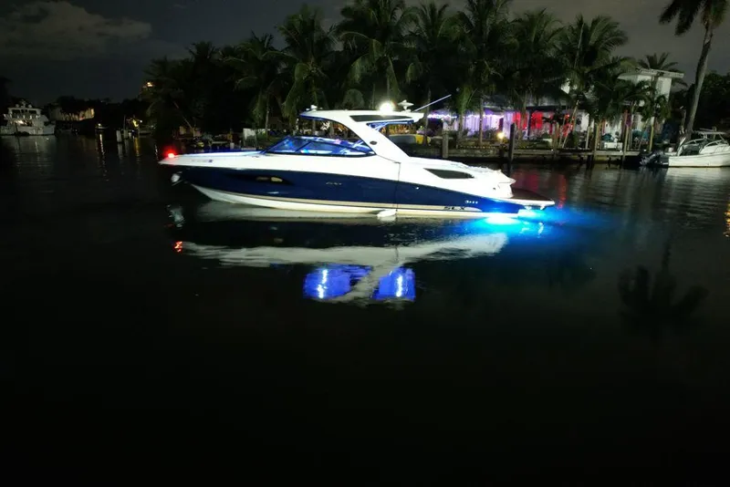 Slide: The Image of 2015 Sea Ray 350 SLX boat illuminated at night on calm water. - 5