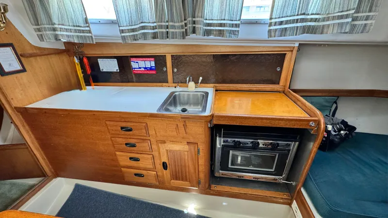 Slide: The Image of 1970 CAL 29 yacht interior with wooden cabinetry, sink, and oven. - 18
