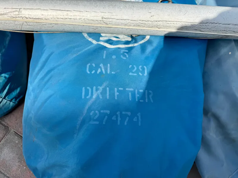 Slide: The Image of Blue sail bag labeled "CAL 29 Drifter 27474" with a white rope on top. - 28