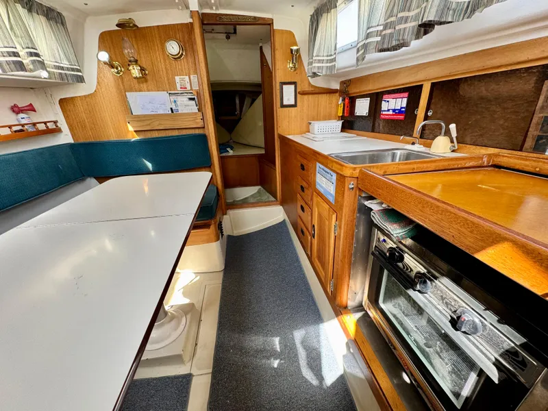 Slide: The Image of Interior of a 1970 CAL 29 sailboat with kitchen and seating area. - 4