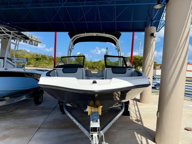 Slide: The Image of 2025 Yamaha Boats AR190 under a blue canopy, parked on a trailer. - 2