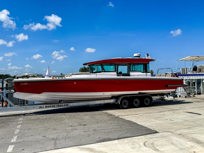 The Image of 2023 Axopar 37 XC CROSS CABIN boat on trailer under clear blue sky. - 0