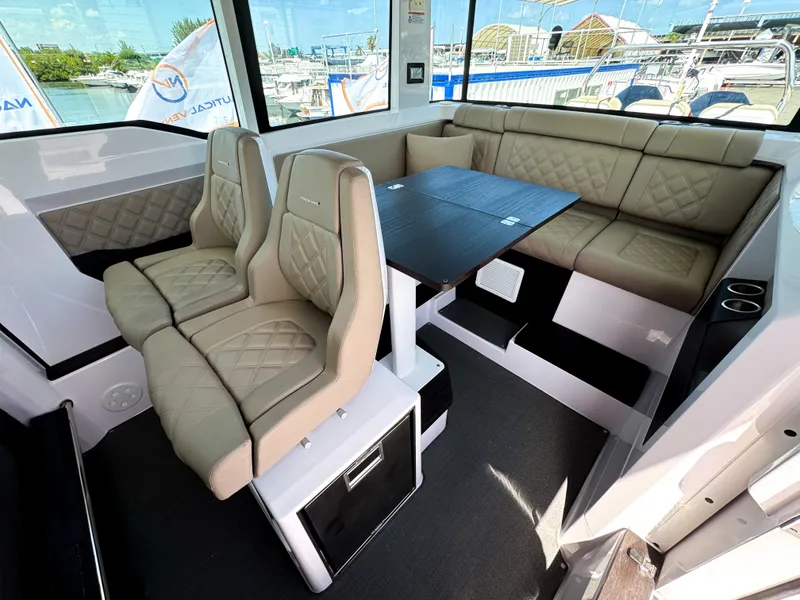 Slide: The Image of Interior of 2023 Axopar 37 XC CROSS CABIN with beige seating and table. - 11