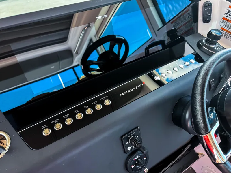 Slide: The Image of 2023 Axopar 37 XC CROSS CABIN dashboard with steering wheel and control panel. - 13