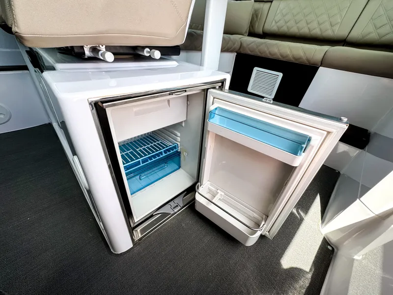Slide: The Image of Open mini fridge inside 2023 Axopar 37 XC CROSS CABIN boat interior. - 16