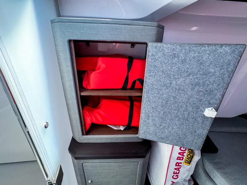 Slide: The Image of Storage cabinet with red life jackets inside Axopar 37 XC CROSS CABIN, 2023 model. - 22