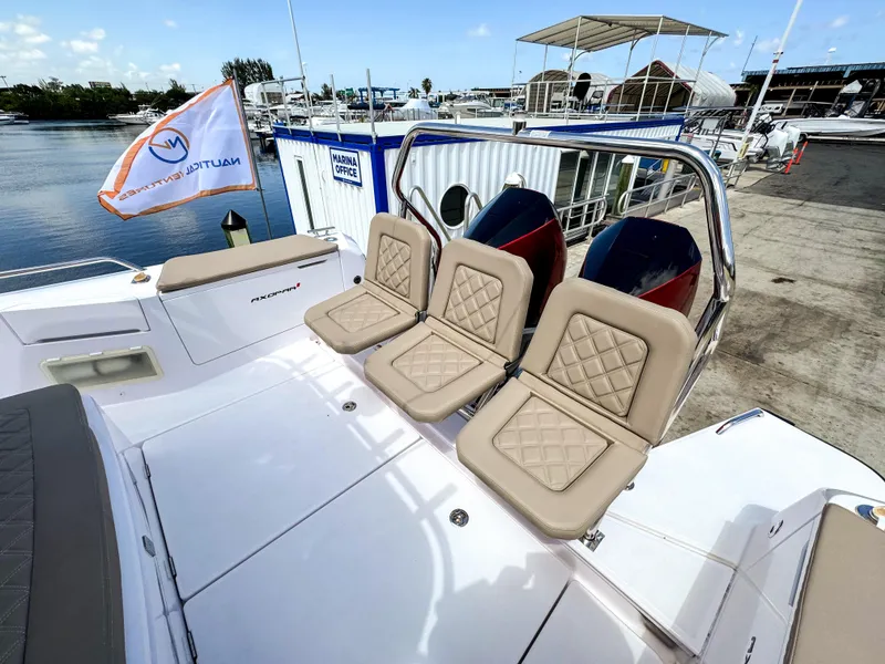 Slide: The Image of 2023 Axopar 37 XC CROSS CABIN with beige seating, docked at a marina. - 25
