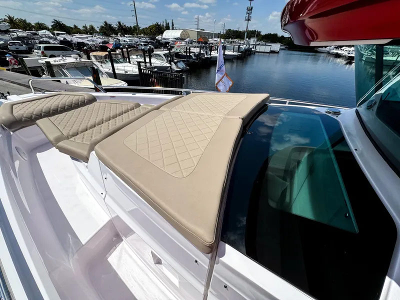 Slide: The Image of 2023 Axopar 37 XC CROSS CABIN with beige seating, docked at a marina. - 26