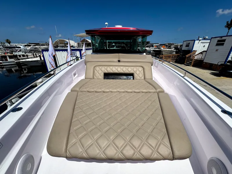 Slide: The Image of 2023 Axopar 37 XC CROSS CABIN with beige quilted seating, docked at a marina. - 27