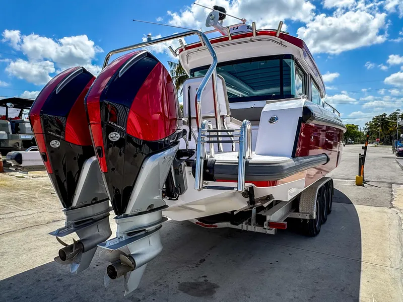 Slide: The Image of 2023 Axopar 37 XC CROSS CABIN with dual outboard engines, docked under a sunny sky. - 6