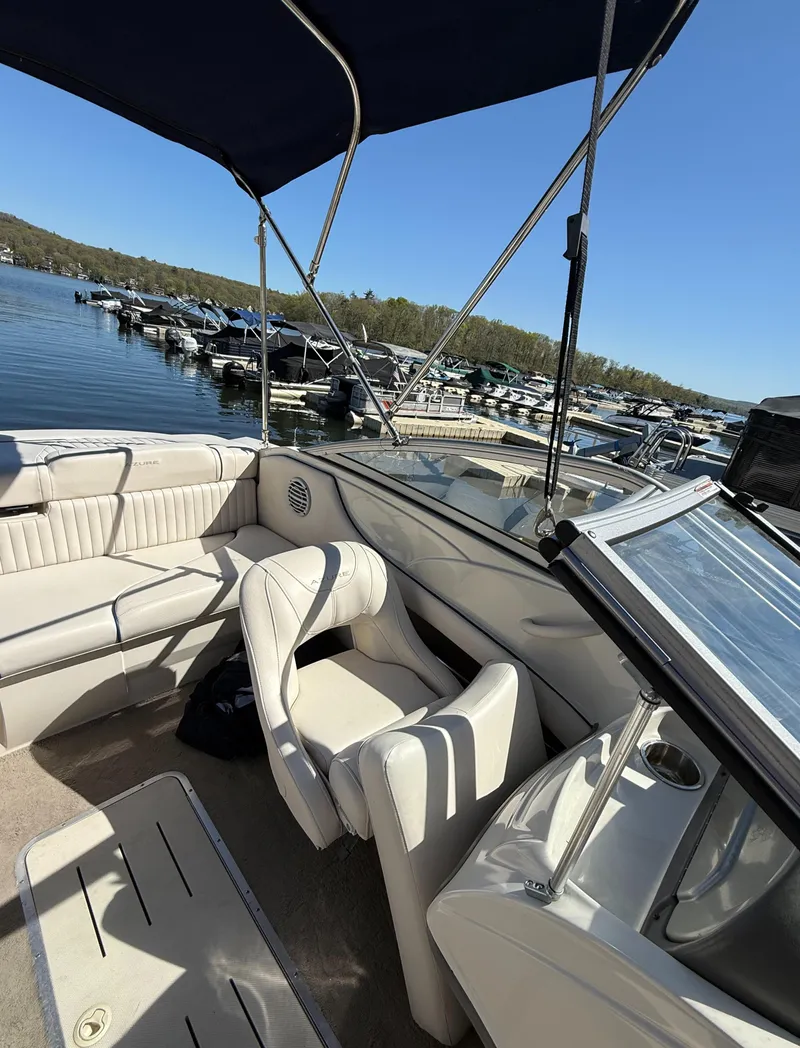 Slide: The Image of 2006 Azure AZ188 boat interior with seating, docked at a scenic lake. - 11