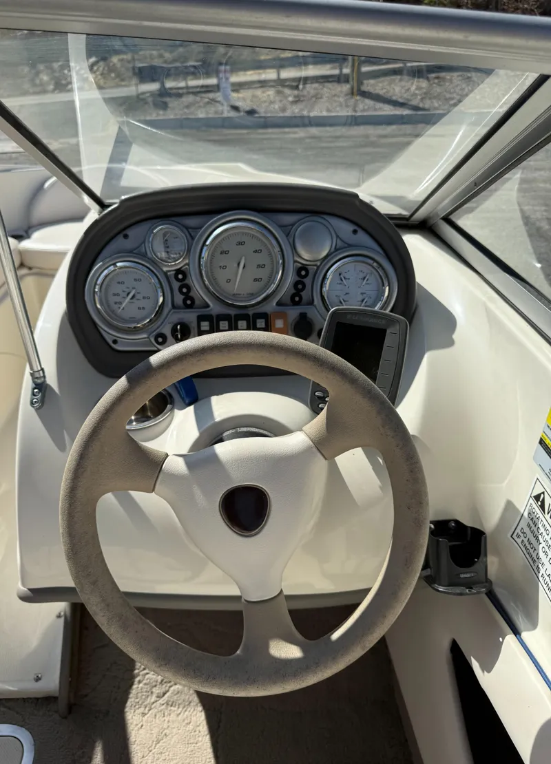 Slide: The Image of Steering wheel and dashboard of a 2006 Azure AZ188 boat, featuring gauges and controls. - 13