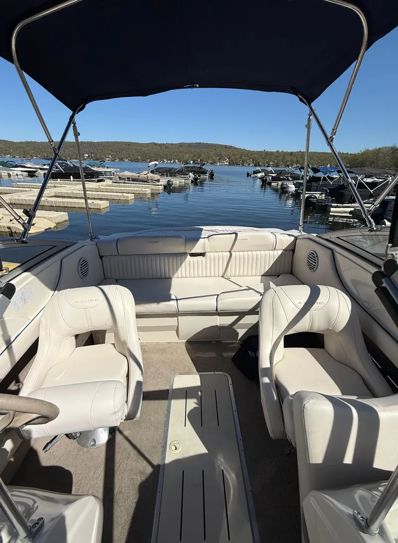 Slide: The Image of Interior of a 2006 Azure AZ188 boat with seating, docked at a scenic lake. - 14