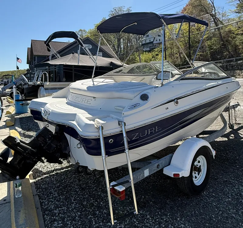 Slide: The Image of 2006 Azure AZ188 boat on trailer, parked outdoors with canopy and ladder. - 2