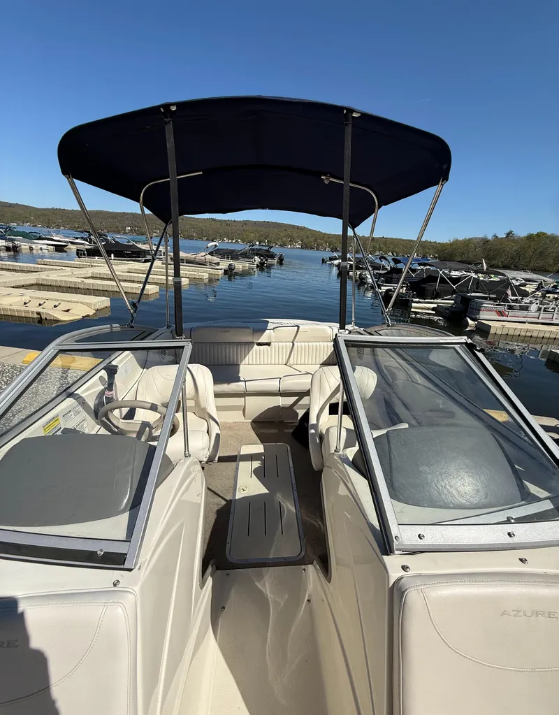 Slide: The Image of 2006 Azure AZ188 boat with canopy, docked at a scenic marina. - 4