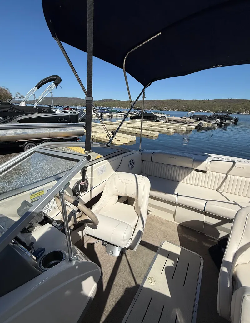 Slide: The Image of 2006 Azure AZ188 boat interior with seating, docked at a scenic lake. - 9